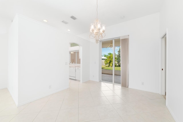 tiled empty room with an inviting chandelier