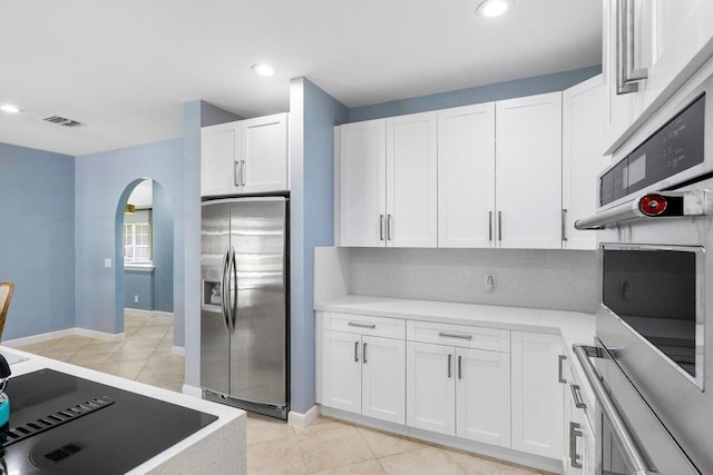 kitchen featuring white cabinetry, stainless steel fridge, and light tile patterned flooring