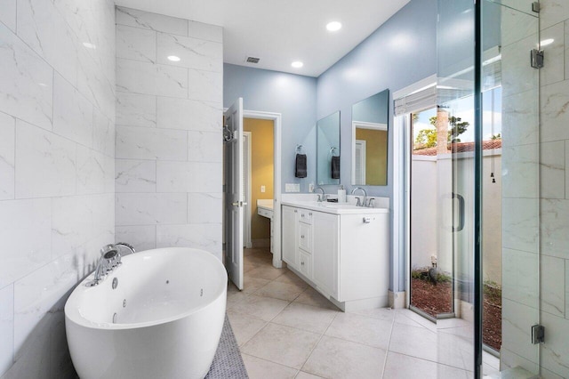 bathroom with tile patterned flooring, vanity, tile walls, and shower with separate bathtub