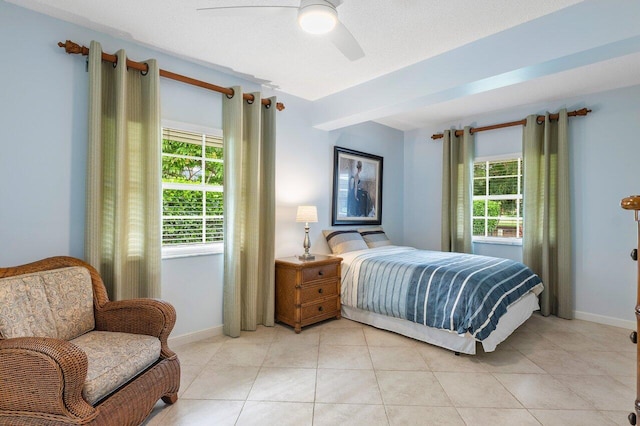 bedroom featuring ceiling fan, light tile patterned floors, and multiple windows