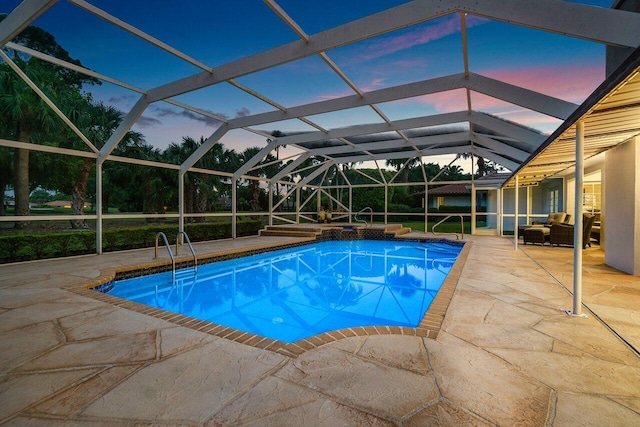 pool at dusk with a lanai, outdoor lounge area, and a patio