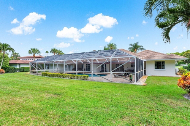 back of house featuring glass enclosure and a lawn