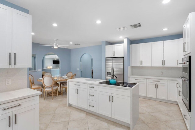 kitchen featuring white cabinetry, stainless steel fridge with ice dispenser, black electric stovetop, and ceiling fan