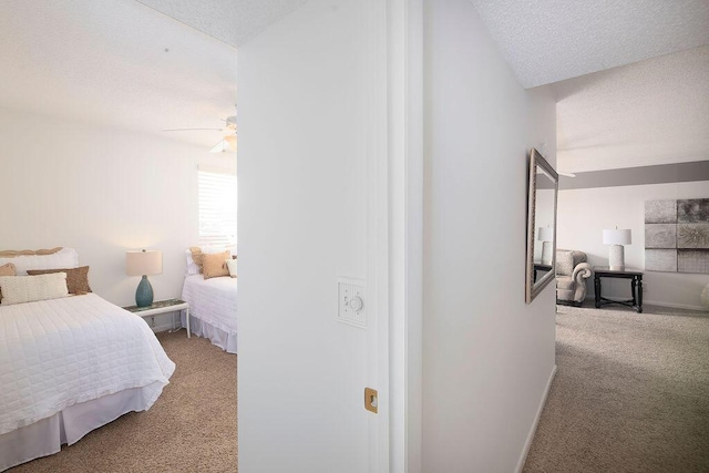 bedroom featuring ceiling fan, light colored carpet, and a textured ceiling