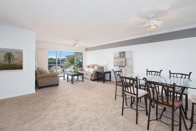 dining room featuring a textured ceiling, ceiling fan, crown molding, and light carpet