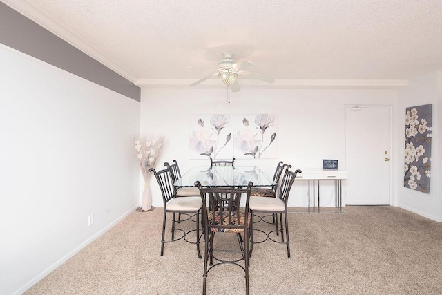 dining space featuring ceiling fan, light colored carpet, a textured ceiling, and ornamental molding