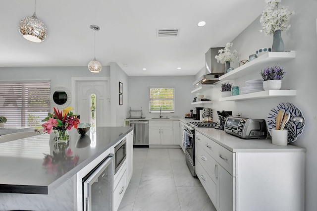 kitchen featuring sink, decorative light fixtures, stainless steel appliances, and white cabinets