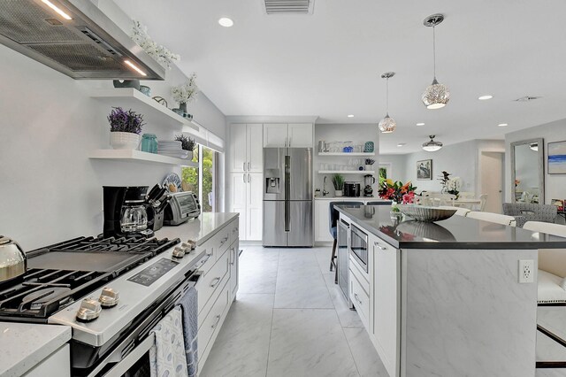 kitchen with white cabinets, hanging light fixtures, wine cooler, appliances with stainless steel finishes, and a kitchen island