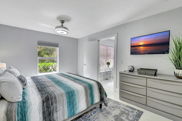 bedroom featuring multiple windows, light tile patterned floors, and ensuite bath