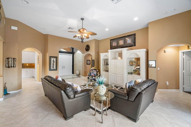 tiled living room featuring ceiling fan and high vaulted ceiling