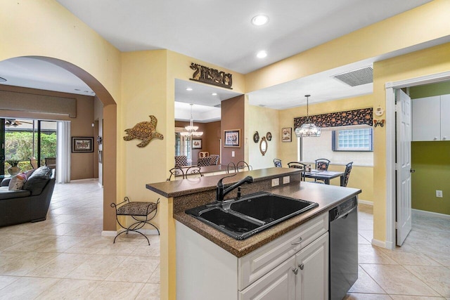 kitchen featuring pendant lighting, white cabinets, a center island with sink, sink, and black dishwasher