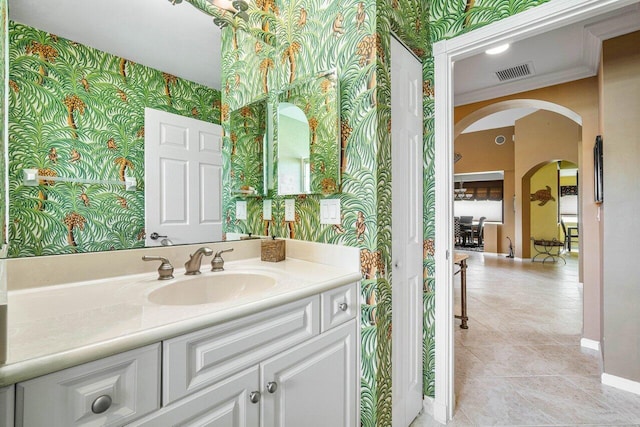 bathroom featuring tile patterned floors, crown molding, and vanity