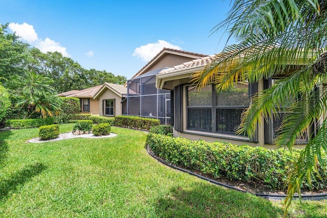 exterior space with glass enclosure and a front lawn