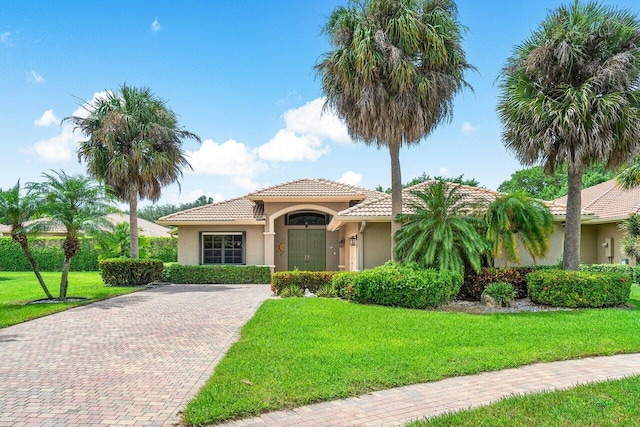 mediterranean / spanish home featuring a front lawn