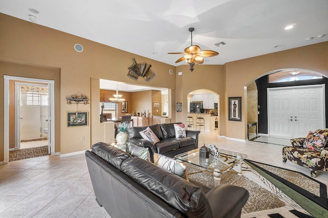 living room featuring ceiling fan with notable chandelier and light tile patterned floors