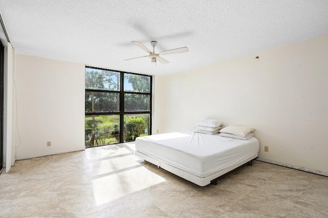 bedroom featuring ceiling fan and a textured ceiling