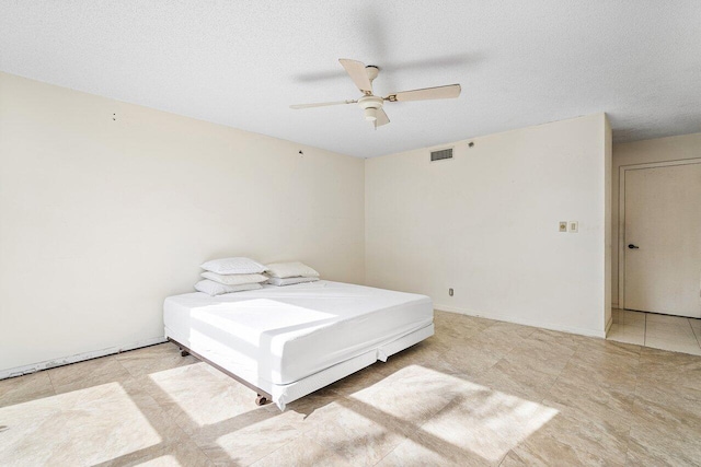 bedroom featuring ceiling fan and a textured ceiling