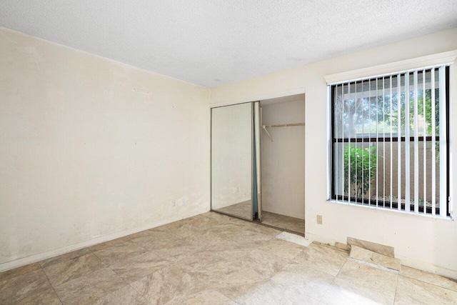 unfurnished bedroom with a closet and a textured ceiling