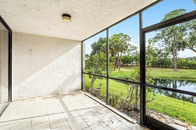 unfurnished sunroom featuring a water view and plenty of natural light