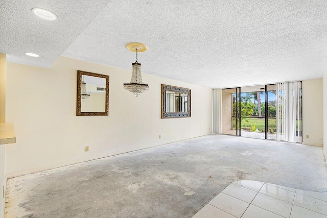 unfurnished room featuring floor to ceiling windows and a textured ceiling