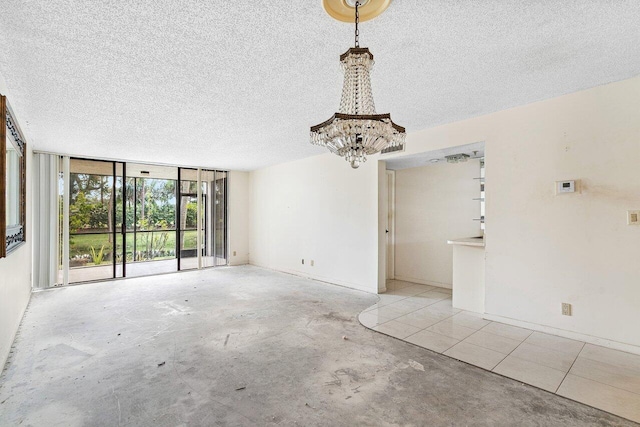 unfurnished room with floor to ceiling windows and a textured ceiling