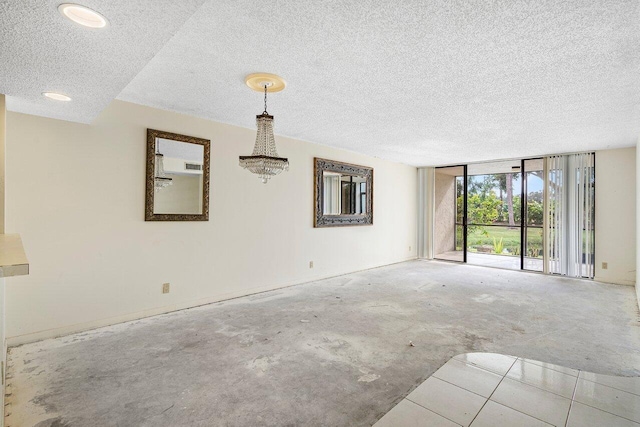 empty room featuring expansive windows and a textured ceiling