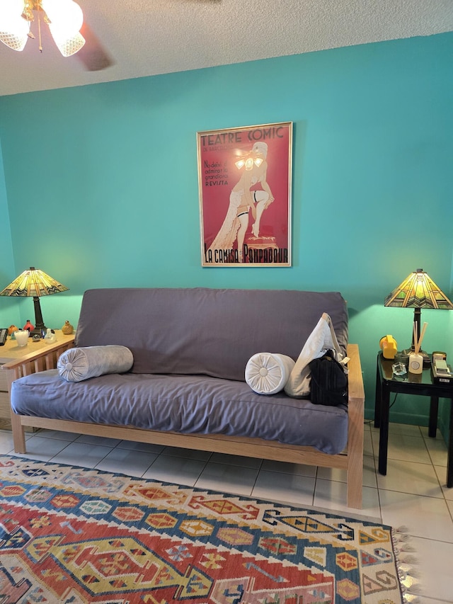 tiled living room featuring ceiling fan and a textured ceiling