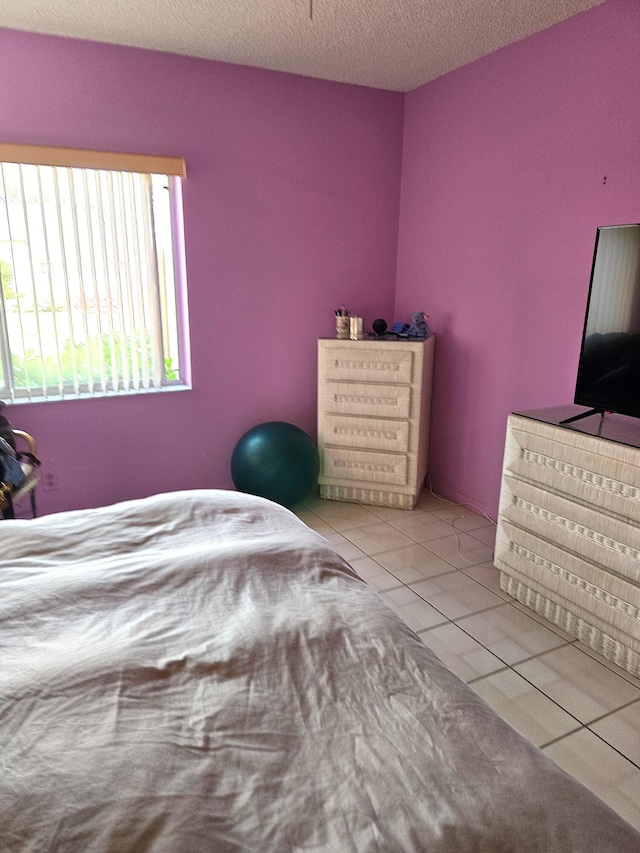 unfurnished bedroom featuring light tile patterned flooring and a textured ceiling