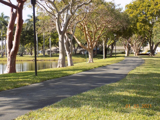 surrounding community featuring a lawn and a water view