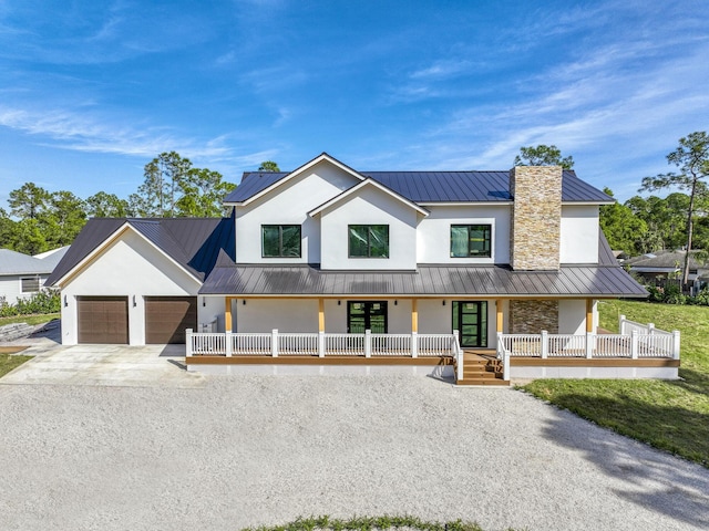 modern inspired farmhouse with a porch and a garage