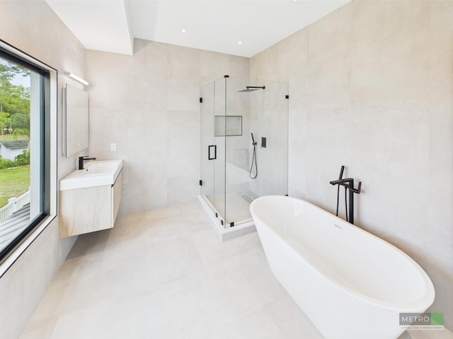13613 157th Ct N, Jupiter, FL 33478 - full bathroom with a stall shower, a soaking tub, vanity, and tile walls