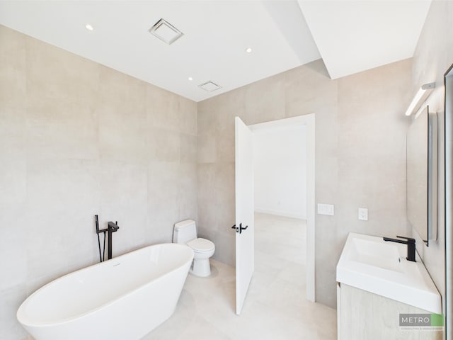 13613 157th Ct N, Jupiter, FL 33478 - bathroom with a freestanding tub, vanity, tile walls, and toilet