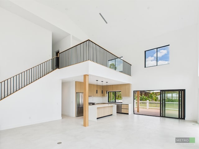 13613 157th Ct N, Jupiter, FL 33478 - unfurnished living room featuring a towering ceiling and baseboards