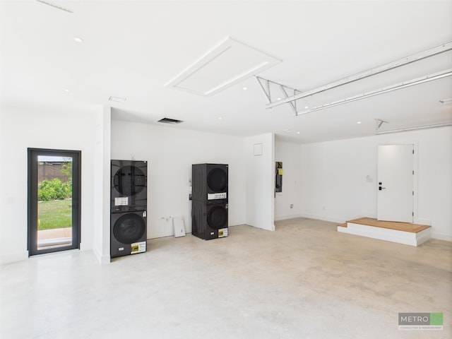 13613 157th Ct N, Jupiter, FL 33478 - unfurnished living room featuring stacked washer / drying machine, attic access, and finished concrete floors