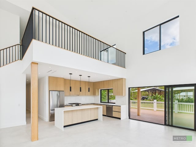 13613 157th Ct N, Jupiter, FL 33478 - kitchen with appliances with stainless steel finishes, modern cabinets, a kitchen island, light countertops, and a towering ceiling