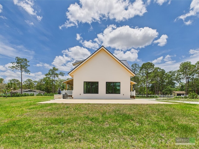 13613 157th Ct N, Jupiter, FL 33478 - rear view of house featuring stucco siding, a patio, and a yard