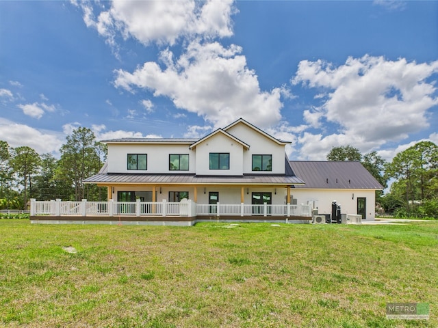 13613 157th Ct N, Jupiter, FL 33478 - back of house with stucco siding, a yard, metal roof, and a standing seam roof