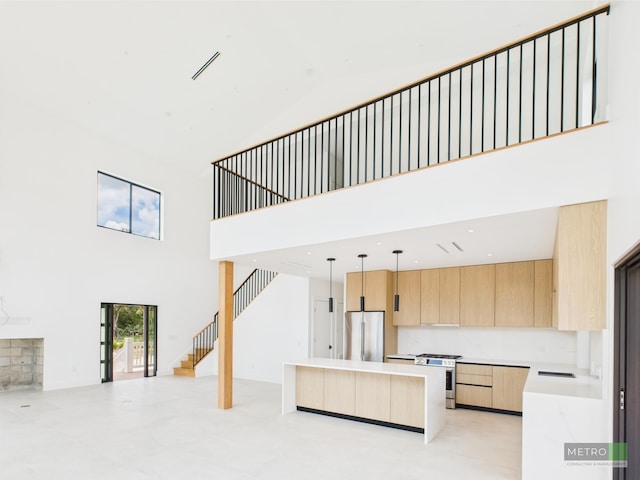 13613 157th Ct N, Jupiter, FL 33478 - kitchen featuring stainless steel appliances, light brown cabinets, a towering ceiling, open floor plan, and modern cabinets