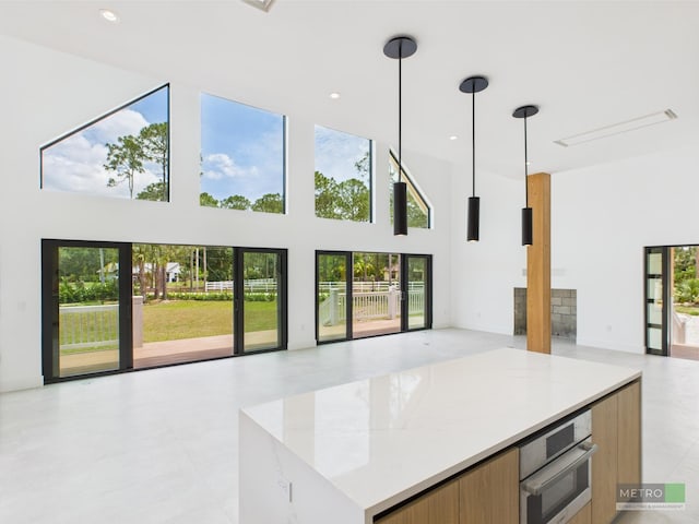 13613 157th Ct N, Jupiter, FL 33478 - unfurnished living room with a towering ceiling, healthy amount of natural light, a fireplace, and recessed lighting