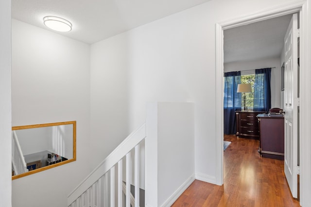 hallway with hardwood / wood-style floors