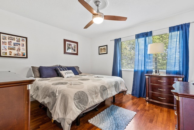 bedroom with dark hardwood / wood-style floors and ceiling fan