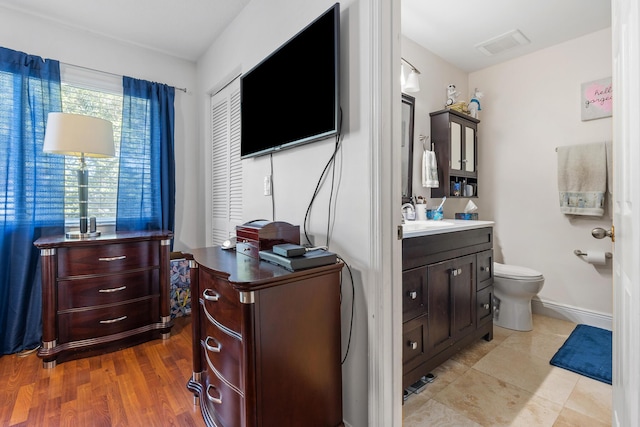 bathroom with wood-type flooring, vanity, and toilet