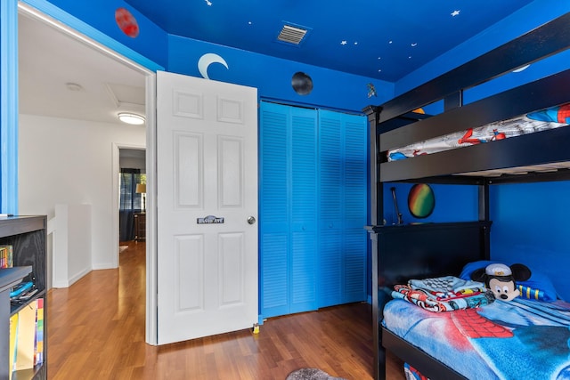 bedroom with wood-type flooring and a closet