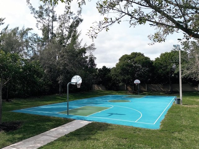 view of sport court with a lawn