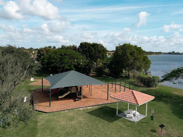 view of home's community featuring a playground, a water view, and a yard