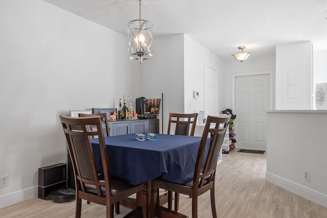 dining space with light hardwood / wood-style floors and a textured ceiling