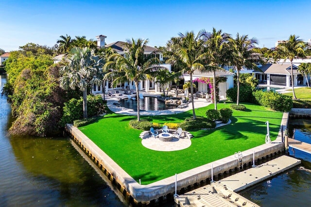 exterior space with a yard, a water view, a fire pit, and a patio area