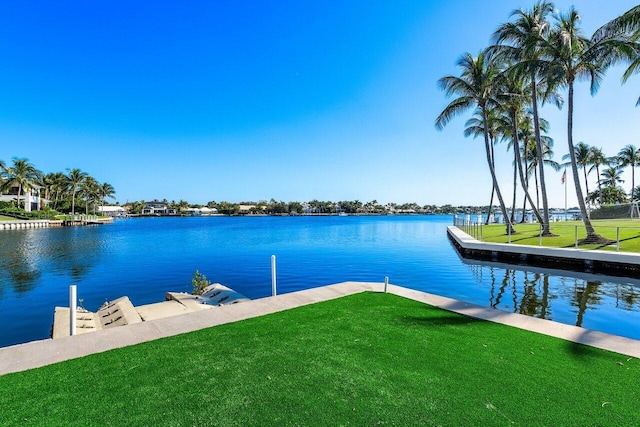 dock area featuring a lawn and a water view