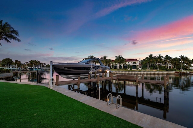 view of dock with a water view and a lawn