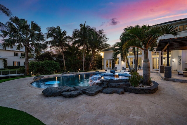 pool at dusk featuring a patio area